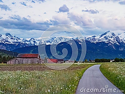 Road in Werdenfelser Land near village Farchant against the backdrop of Wetterstein Mountains, Bavaria, Germany Stock Photo