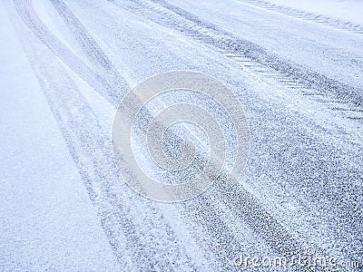 Asphalt covered with snow and imprints of tire tracks Stock Photo