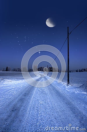 Road in winter evening with moon Stock Photo