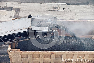 Road works. Asphalt removing machine loading powdered asphalt on the truck Stock Photo