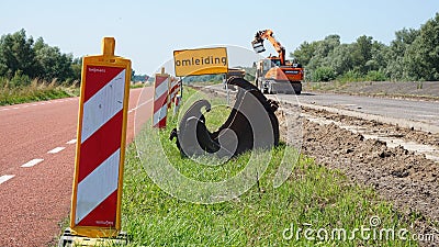 Road works on asphalt road. Road work by contractor and excavation workers constructing paving Stock Photo