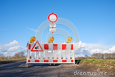 Roadblock with German traffic sign. Road closed with a barrier for protection of amphibians during toad migration period in spring Stock Photo