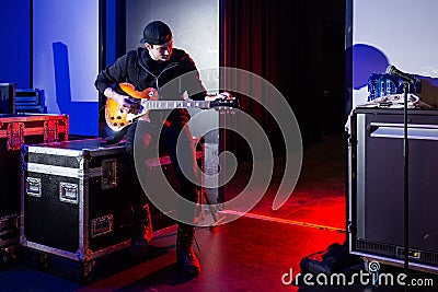 Roadie tuning a guitar for the guitarist Stock Photo