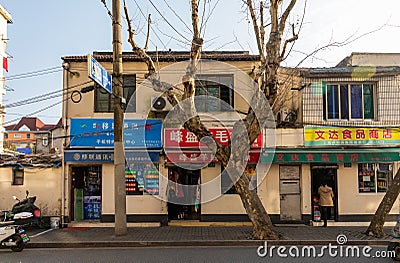 Roadside traditional stores selling mobile phones, wool products, foods on Wan`an Rd in Jiangwanzhen Editorial Stock Photo