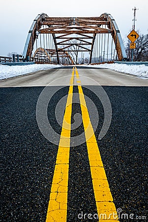 Roadway yellow lane leading to complex modern geometrical bridge Stock Photo