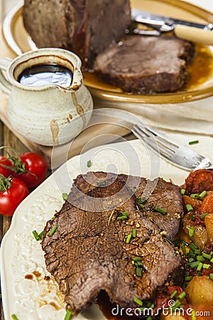 Roast beef joint with roast vegetables Stock Photo