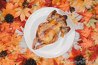 Roast chicken with Autumn and Fall season background. Fake maple leaf on wood table. Harvest cornucopia and Thanksgiving day Stock Photo