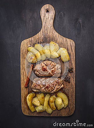 Roast duck breast with apples and cloves cutting board on wooden rustic background top view close up Stock Photo