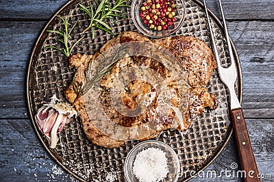Roast pork with garlic, salt and red sauce on iron baking tray rusticwith fork on wooden rustic background, top view, close up Stock Photo