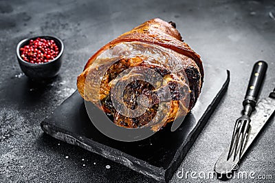 Roast pork knuckle with pink pepper and spices. Black background. Top view Stock Photo