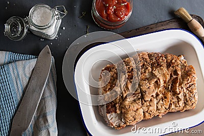 Roast pork in roasting tin with sauce, marinade, ingredients & utensils Stock Photo