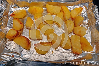 Roast potatoes being cooked in a pan Stock Photo