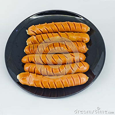 Roast sausages on black dish Stock Photo