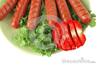 Roast sausages on green dish Stock Photo