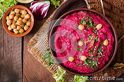 Roasted Beet Hummus with toast in a ceramic bowl on a dark background. Stock Photo