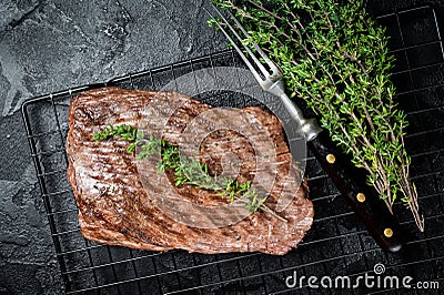 Roasted medium rare flank beef steak with thyme. Black background. Top view Stock Photo