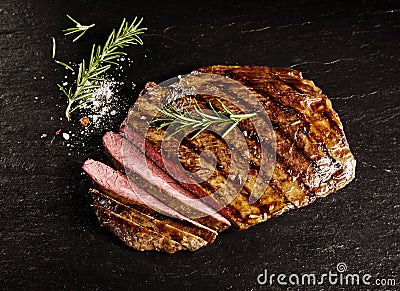 Roasted medium rare sliced flank beef with rosemary Stock Photo