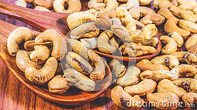 Roasted cashew nuts on a wooden spoon.Roasted salted cashew nuts on white background Stock Photo