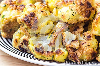 Roasted cauliflower in white plate on wooden background Stock Photo