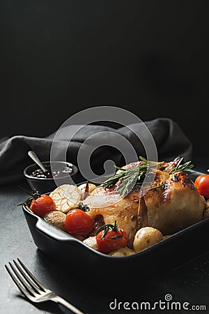 Roasted chicken with vegetables on black. Oven baked food. Stock Photo