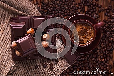 Roasted coffee beans, chocolate, nuts and cup on the wooden background Stock Photo