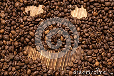 Roasted coffee beans in the form of a smiling face on a wooden background Stock Photo