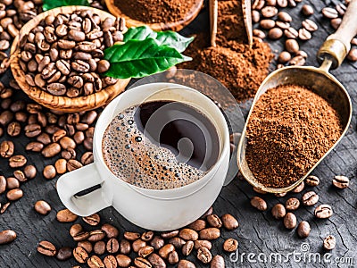 Roasted coffee beans, ground coffee and cup of coffee on wooden Stock Photo