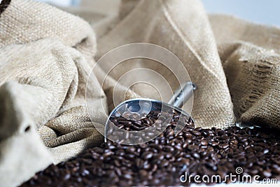 Roasted Coffee beans metal scoop table hessian sack Stock Photo