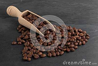 Roasted Coffee Beans Spilling from a Wooden Scoop Stock Photo