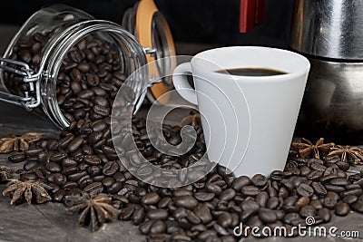 Roasted coffee beans with a white cup and moka pot.Espresso italian coffee maker on dark rustic wooden background with copy space Stock Photo