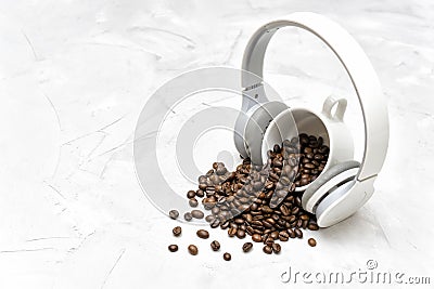 Roasted coffee beans and wireless headphones on a concrete table Stock Photo