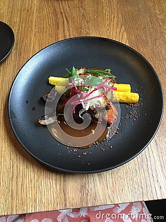 Roasted crispy pork belly dish with vegetables and sauce in a restaurant Stock Photo