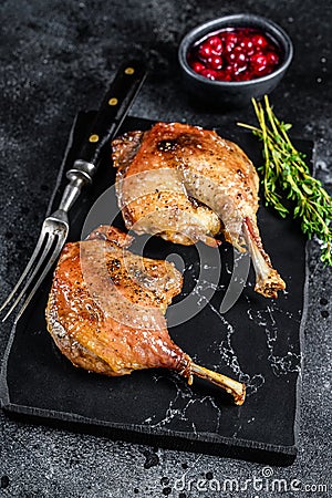 Roasted duck leg confit with cranberrie sauce. Black background. top view Stock Photo