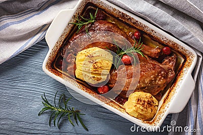 Roasted duck legs with apples and cranberries. Stock Photo