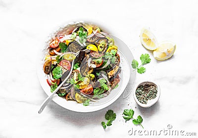 Roasted eggplant, sweet tomato and cilantro mediterranean style salad on light background, top view. Vegetarian food Stock Photo