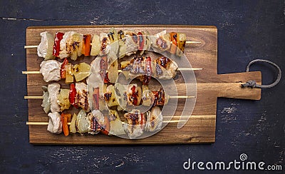 Roasted kebabs on a cutting board with sauce wooden rustic background top view close up Stock Photo