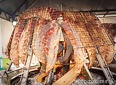 Roasted meat of beef cooked on a vertical grills. Stock Photo