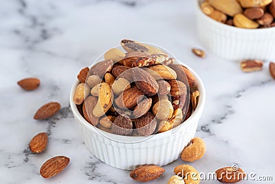 Roasted mixed nuts in white ceramic bowl Stock Photo