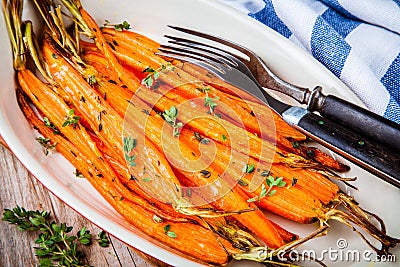 Roasted organic carrots with thyme closeup Stock Photo