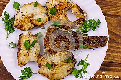 Roasted pollock in white plate on wooden table Stock Photo