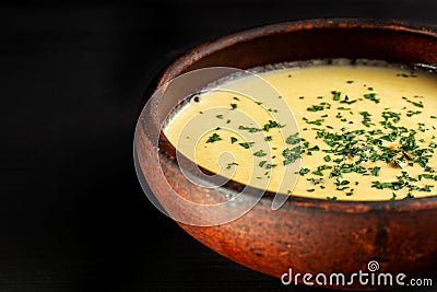 Roasted pumpkin soup with cream on black wooden background. Stock Photo