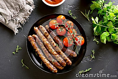 Roasted sausages and cherry tomatoes Stock Photo