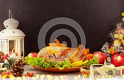 Roasted traditional Turkey with berries and apples on wooden table background with black backdrop. Stock Photo