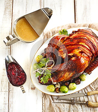 Roasted turkey with bacon and garnished with chestnuts and brussels sprouts. Stock Photo