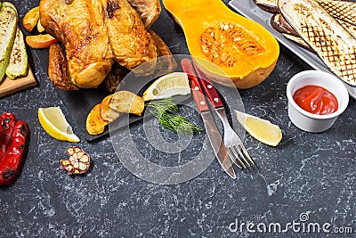 Roasted turkey and grilled zucchini, eggplant and pepper on a rustic stone table Stock Photo