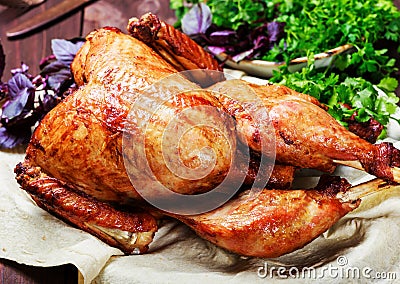 Roasted Turkey. Thanksgiving table served with turkey, decorated with greens and basil on dark wooden background. Homemade food Stock Photo