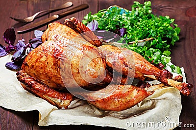 Roasted Turkey. Thanksgiving table served with turkey, decorated with greens and basil on dark wooden background. Homemade roasted Stock Photo