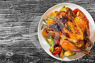 Roasted whole chicken, potatoes, baby carrots, eggplants, green Stock Photo