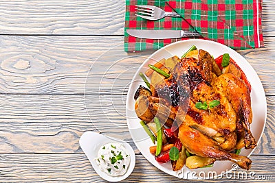 Roasted whole chicken, potatoes, baby carrots, eggplants, green Stock Photo