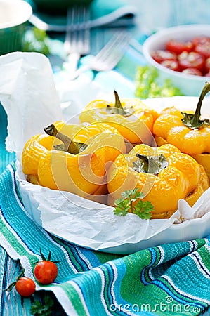 Roasted yellow bell peppers stuffed with quinoa, mushrooms and cheese. Cherry tomatoes baked with parmesan Stock Photo